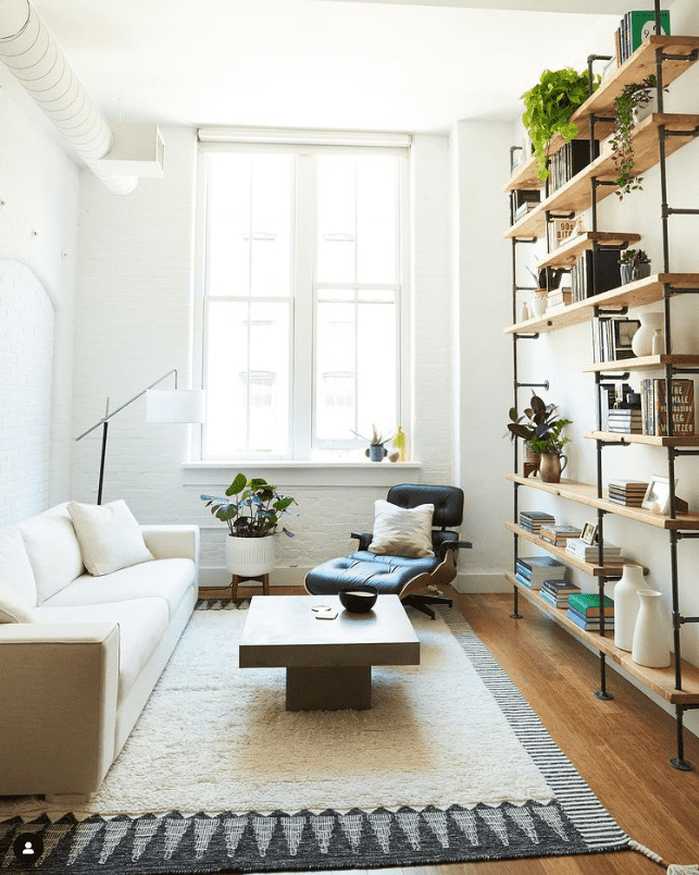 Living room with custom bookshelves with black pipes and wood shelves | Soil & Oak