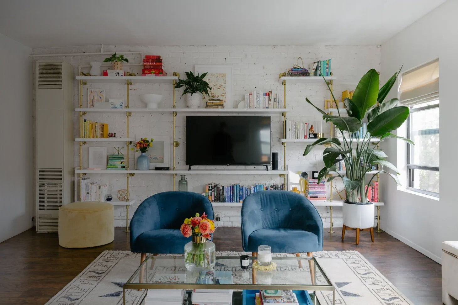 custom bookshelves with brass plated pipes and white shelves in a room designed by Becca Freeman and Emma Beryl Interiors | Soil & Oak