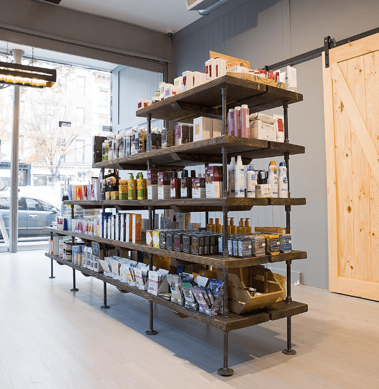 Custom bookshelves black pipes and dark stained wood shelves for pharmacy | Soil & Oak