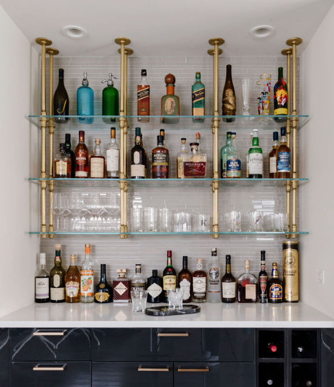 Glass bar shelf filled with liquor bottles | Soil & Oak