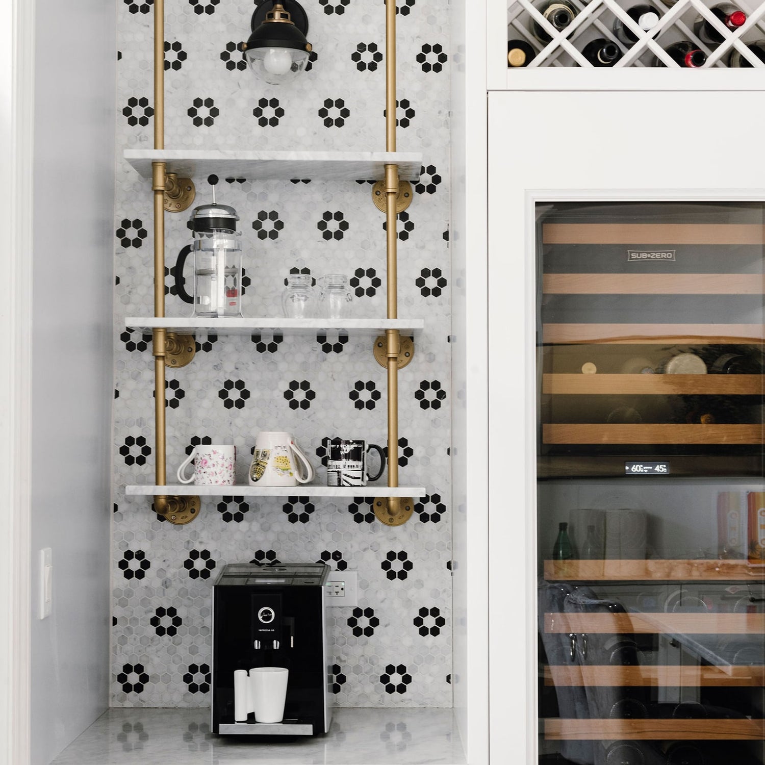 close up photo of wall to ceiling mounted shelves with Irish gold pipes and marble shelves | Soil & Oak