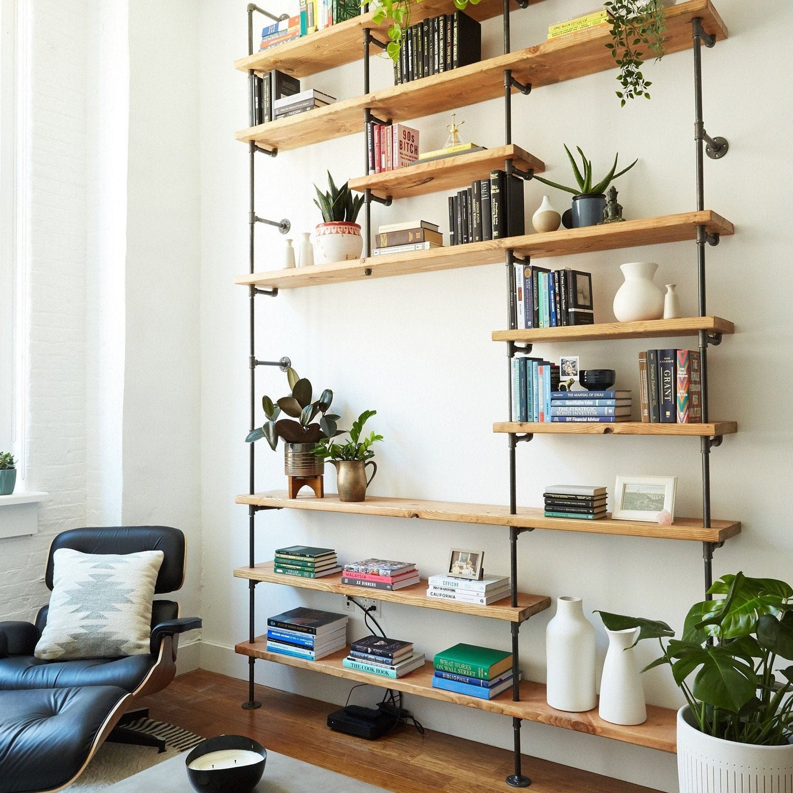 custom bookshelf with back pipes and oak shelves in apartment living room | Soil & Oak