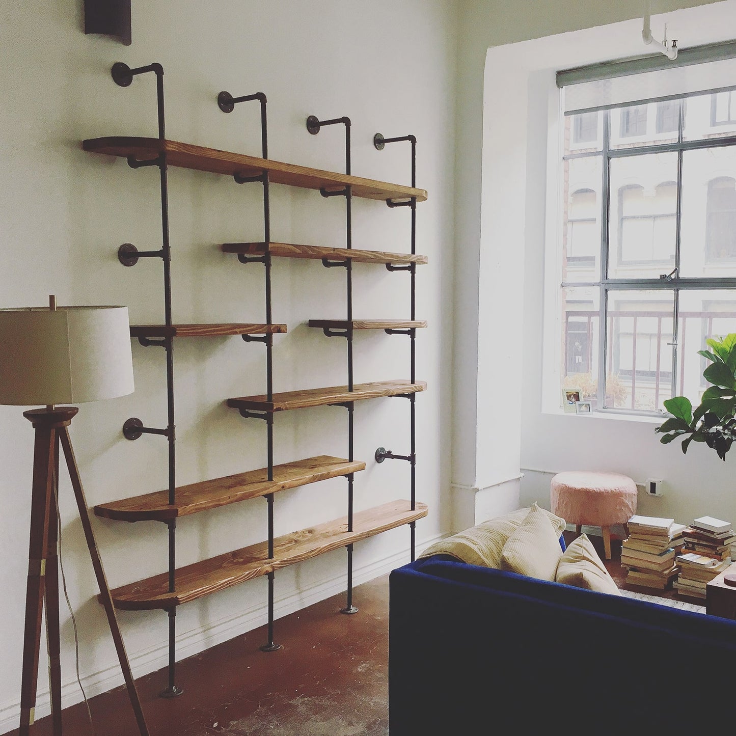 black steel pipe with walnut wood shelves in apartment living room | Soil & Oak