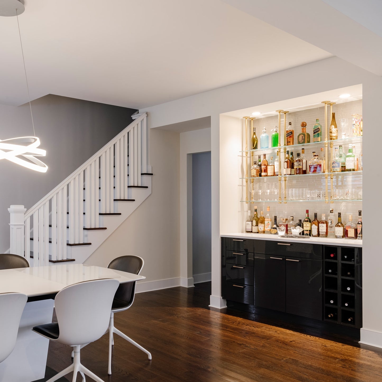 wide photo of ceiling mounted bar and kitchen shelving with brass plated pipes and glass shelves in white tiled bar | Soil & Oak