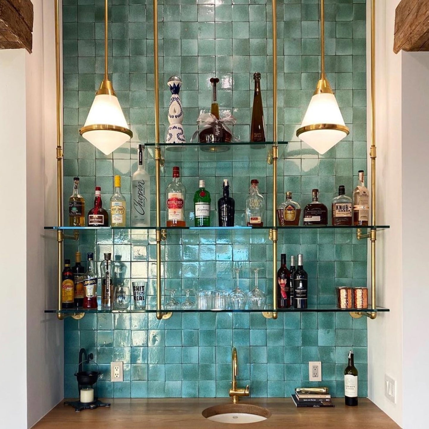 ceiling to wall bar and kitchen shelving with brass plated pipes and glass shelves in front of turquoise tiled bar wall | Soil & Oak