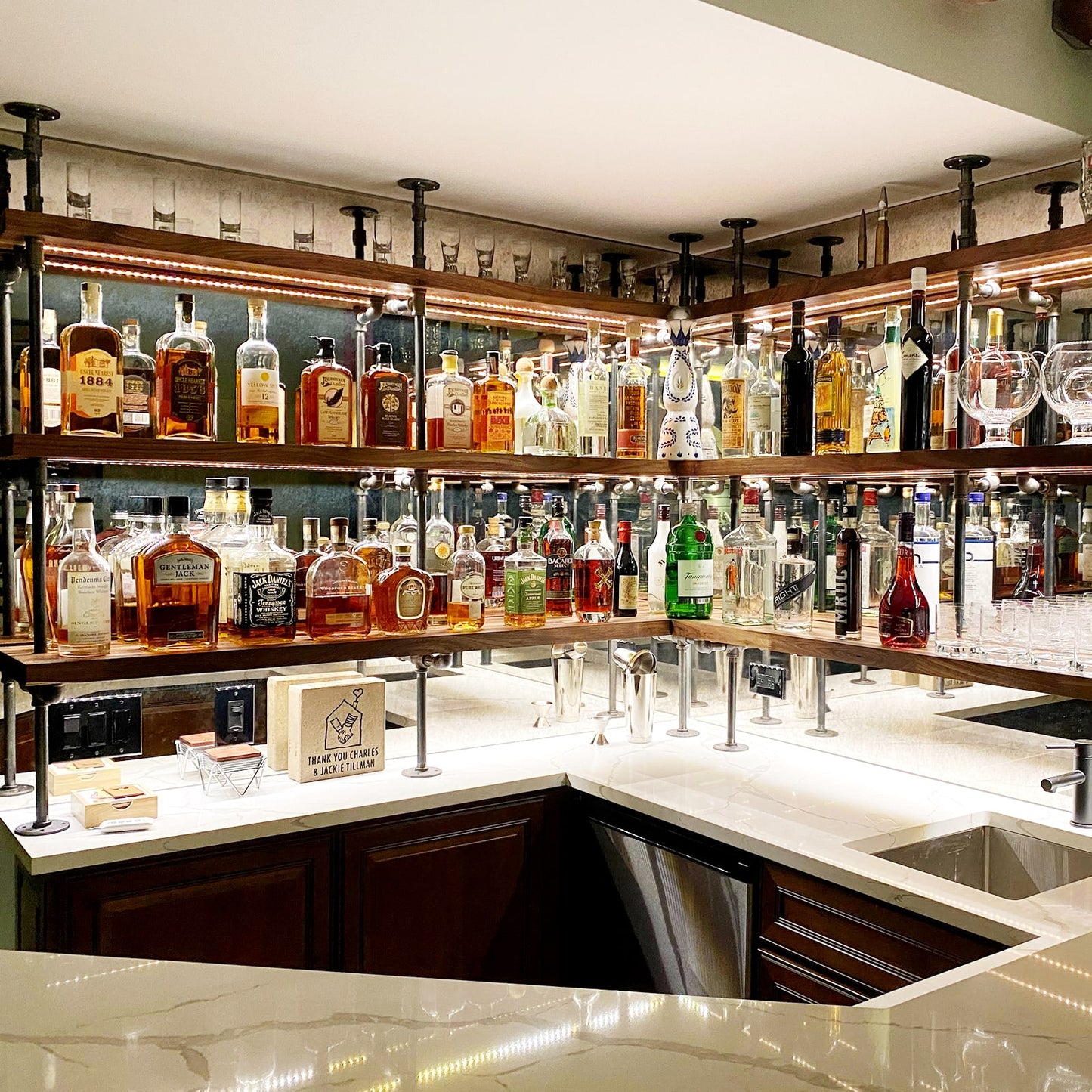 Counter to ceiling shelving with black pipes and walnut shelves in basement bar | Soil & Oak