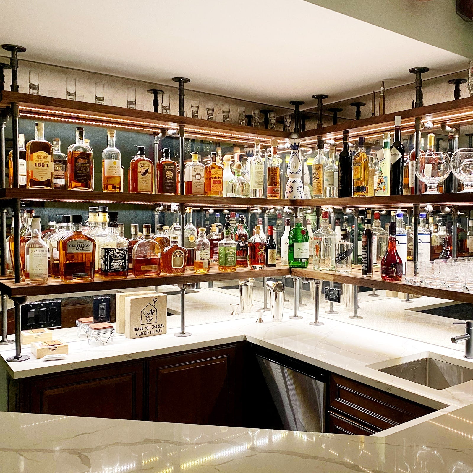 Counter to ceiling shelving with black pipes and walnut shelves in basement bar | Soil & Oak