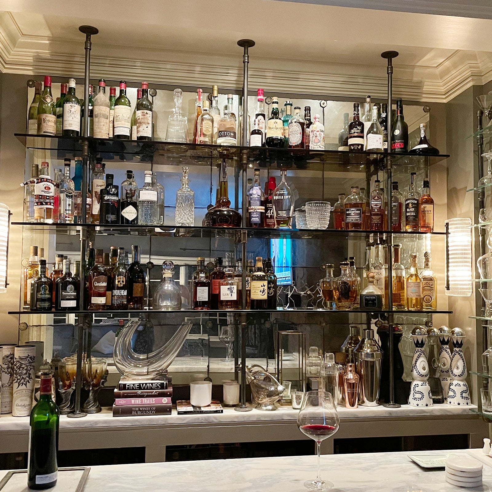 Counter to ceiling shelving with black pipes and glass shelves in bar | Soil & Oak