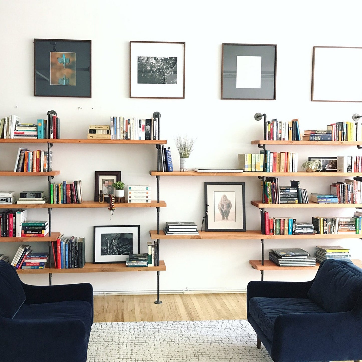 custom bookshelf with black pipes and oak shelves in living room | Soil & Oak