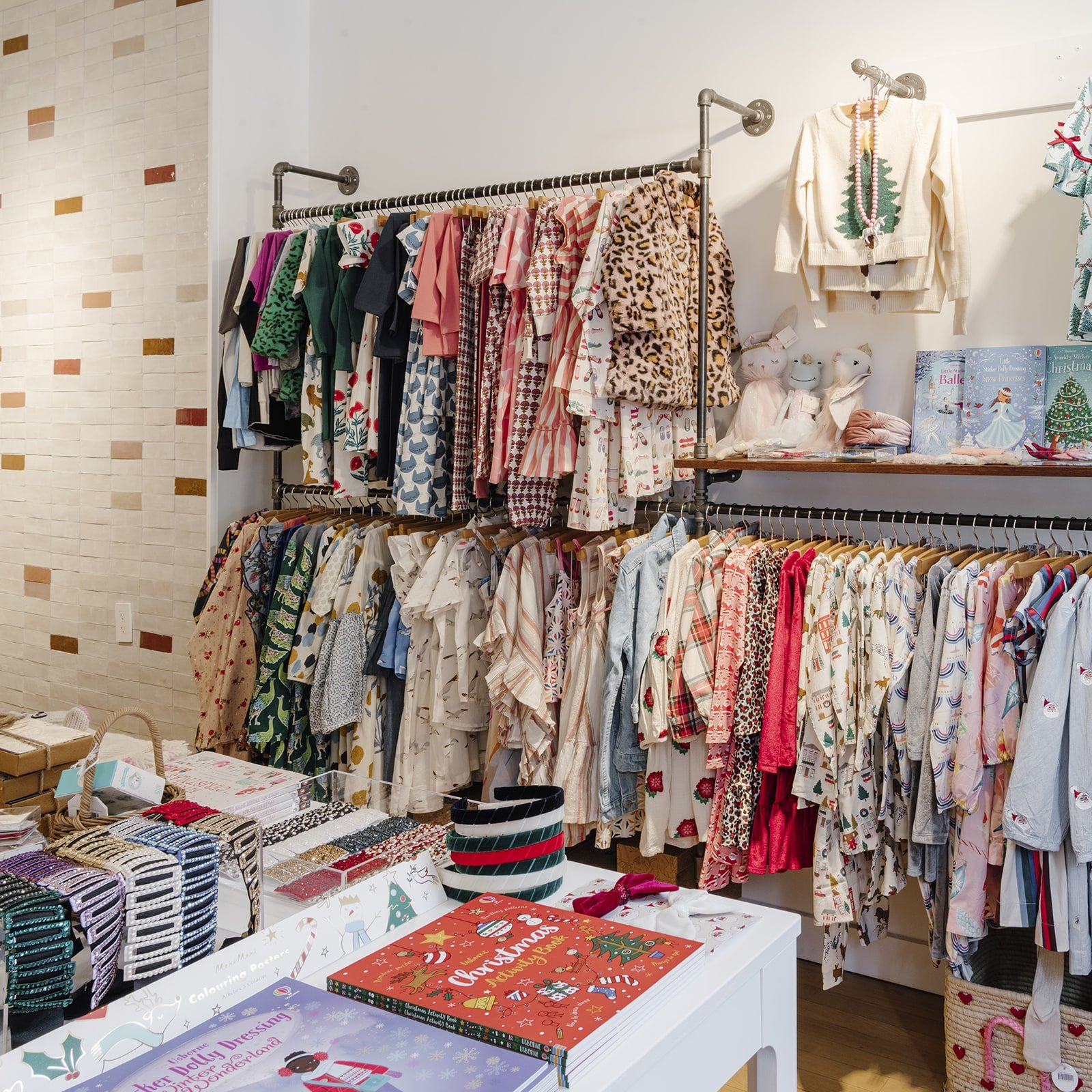 custom retail shelving units with black pipes and wood shelves and pipes used to hang children clothing | Soil & Oak