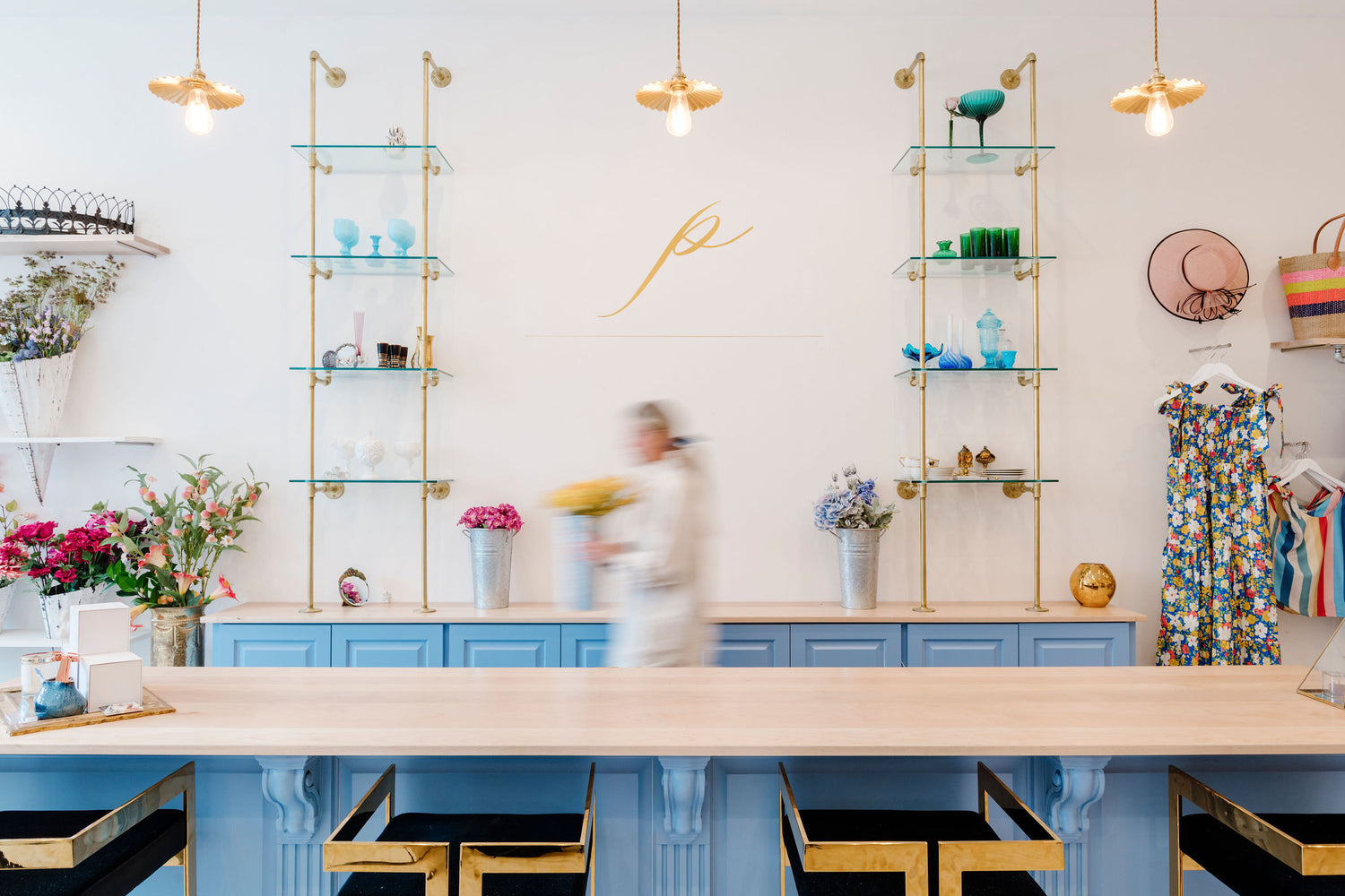 Beautiful brass pipe counter to wall glass shelves in a clothing store | Soil & Oak