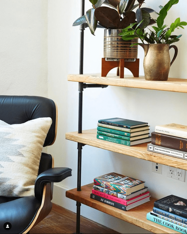 close up of living room bookshelves with black pipes and maple wood shelves