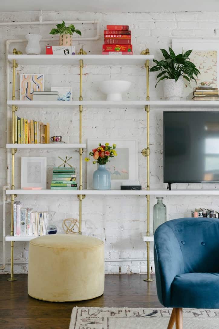 living room custom bookshelves brass plated pipes and white painted wood shelves
