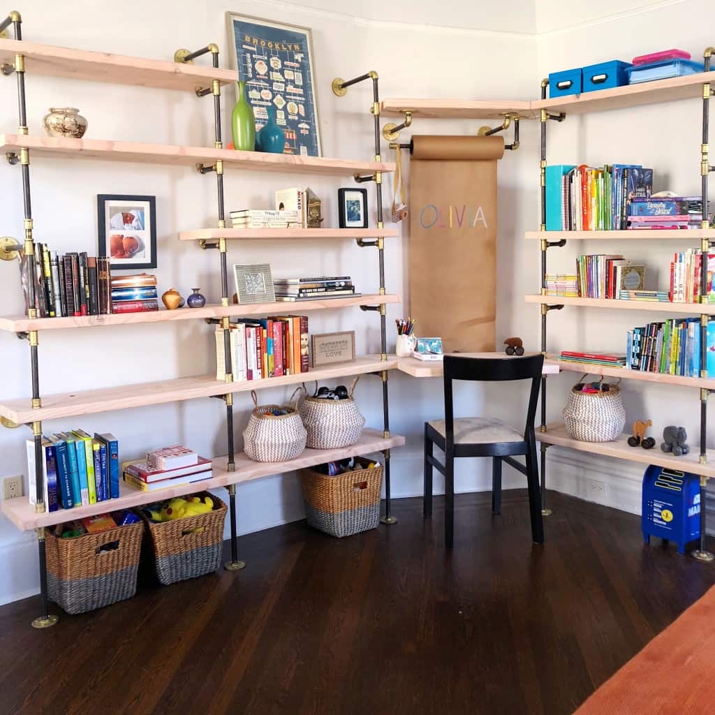 Custom children's room bookshelves with built-in desk with black and brass pipes and maple shelves | Soil & Oak
