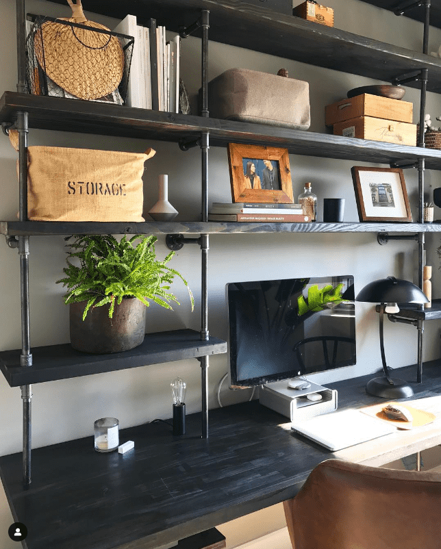 built-in desk and bookshelves unit with black steel raw pipes and black stained butcher block shelves