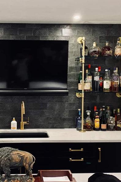 Counter to wall glass shelves with brass pipes in a basement bar | Soil & Oak