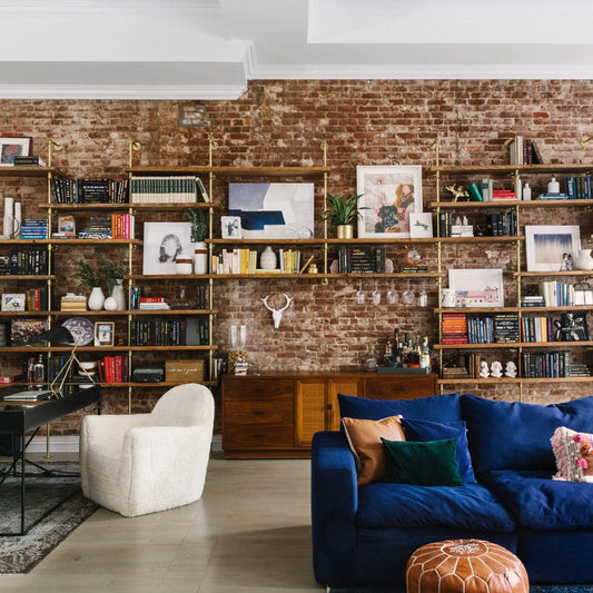 custom soil & oak bookshelf with brass plated pipes and oak shelves in large living room