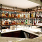 Counter to ceiling shelving with black pipes and walnut shelves in basement bar | Soil & Oak 