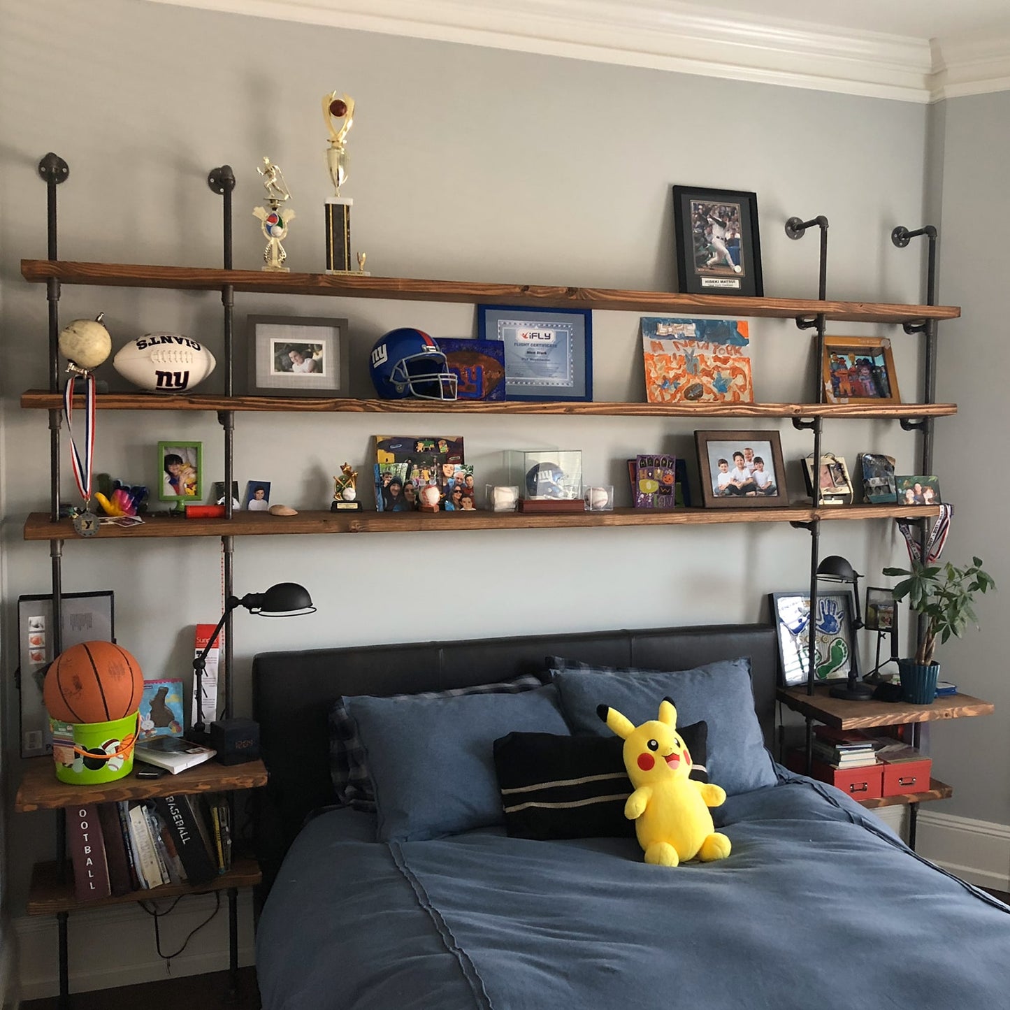 custom soil & oak bookshelf with black pipes and oak shelves in boy's bedroom