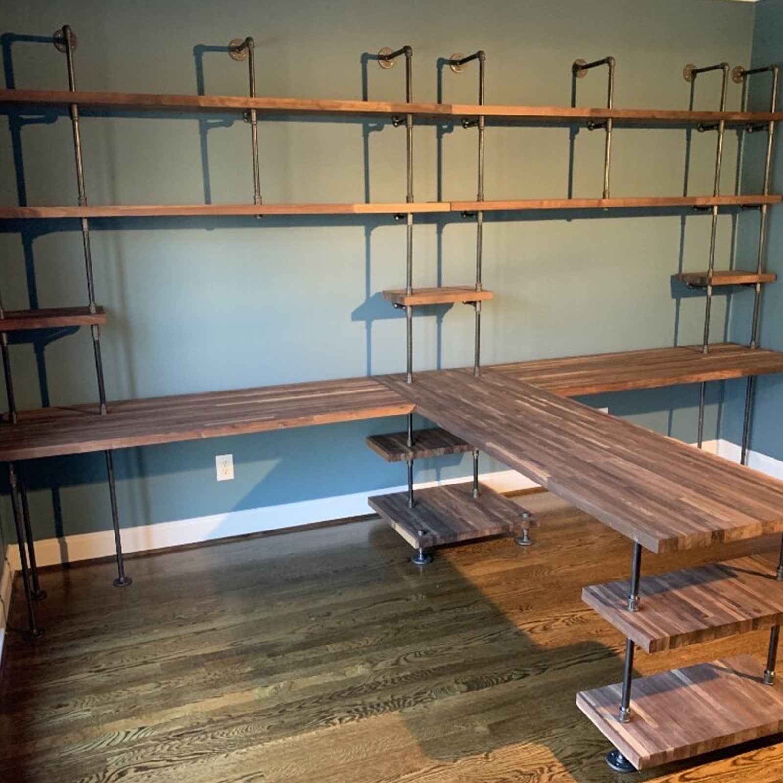 large custom soil & oak double built-in desks with black pipes and walnut shelves