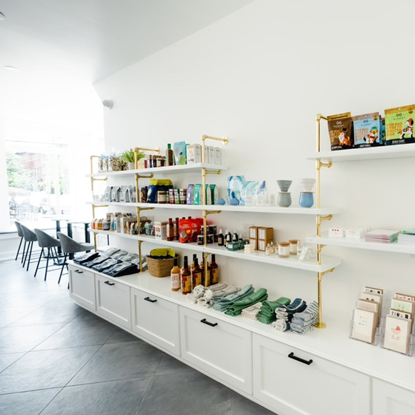 custom white retail shelves with brass plated pipes | Soil & Oak 