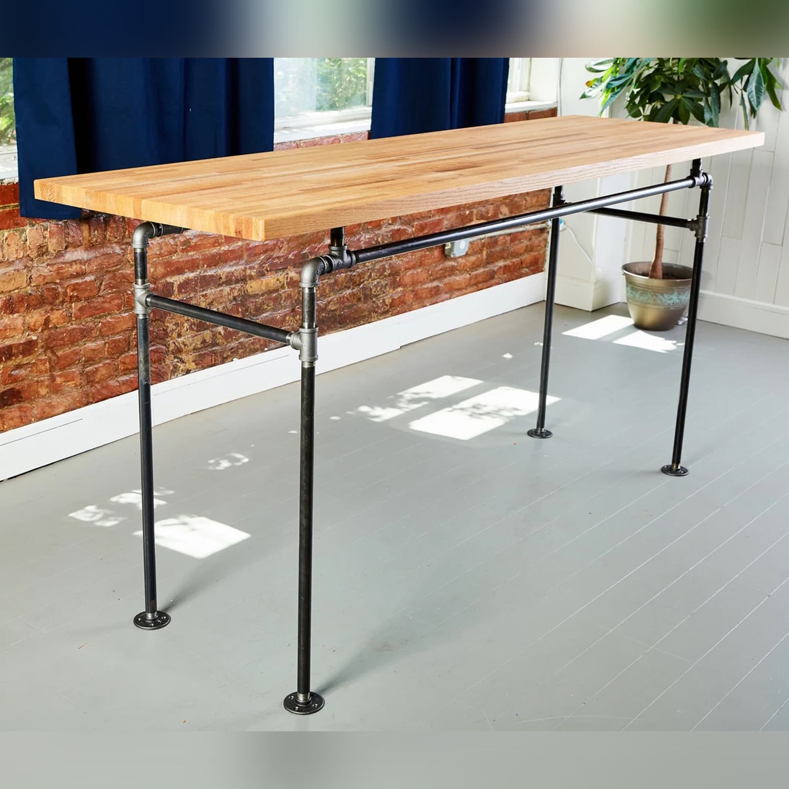 soil & oak standalone desk with black pipe legs and an oak butcher block table top